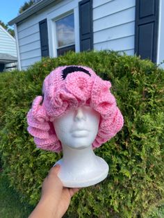 a white mannequin head wearing a pink knitted hat