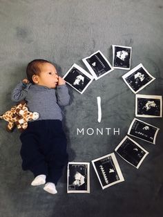 a baby is laying on the floor with pictures around him