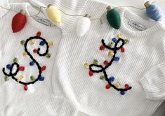 two knitted sweaters with christmas lights on them