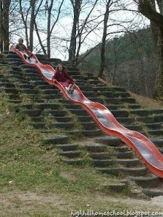 two children slide down the side of a hill