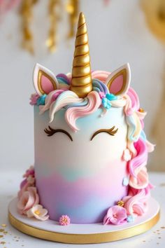 a close up of a cake with a unicorn face on the top and flowers around it