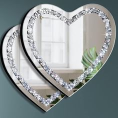 two heart shaped mirrors hanging on the wall