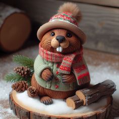 a brown bear figurine sitting on top of a tree stump wearing a hat and scarf