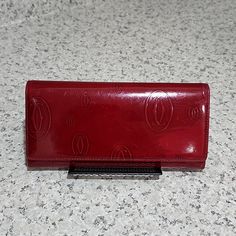 Authenticated By A Reputable Distributor. Cartier Happy Birthday Bordeaux Patent And Calf Leather Wallet In Dark Red. This Beautiful Wallet Is Preowned With Exterior Sign Of Wear (Please See Last Two Pictures) Making This Perfect For The Woman That Wants To Own A Piece Of Luxury At An Affordable Price. There Are No Tears On The Leather. Sides And Pocket Gussets Are Perfect. Flap Opening With Snap Closure. If You Are A Crafty Person, This Wallet Would Look Brand New If You Repaint The Exterior As Red Vintage Leather Wallets, Red Leather Evening Wallet, Vintage Red Bifold Wallet, Red Vintage Bifold Wallet, Red Bifold Evening Bag, Red Bifold Wallet For Formal Use, Red Evening Wallet With Card Slots, Red Bifold Wallet For Formal Occasions, Uniqlo Bags