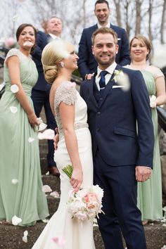 a bride and groom standing in front of their wedding party