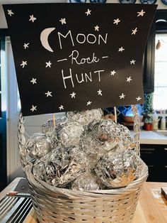 a basket filled with lots of silver foil wrapped in aluminum foil and topped with a sign reading moon rock hunt