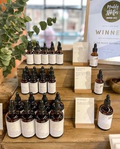 bottles of wine sit on display in front of a wooden table with cards and labels