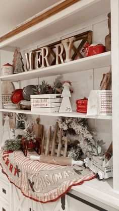 a christmas display in the corner of a room with white cabinets and shelves filled with holiday decorations