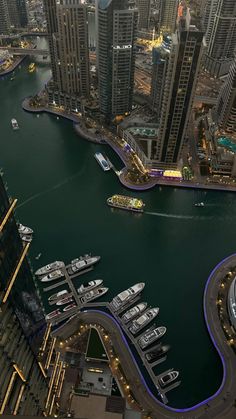 an aerial view of a city with lots of tall buildings and boats in the water