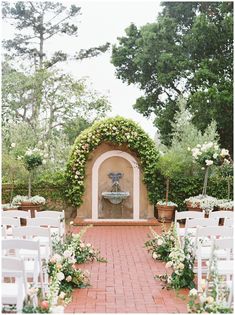 an outdoor ceremony setup with white chairs and flowers