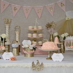 a table topped with lots of cakes and cupcakes