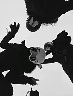 black and white photograph of two people with helmets on their heads looking up at the sky