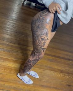 a person with tattoos on their legs and leggings