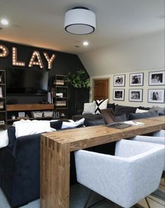 a living room with couches, chairs and a television on the wall that says play