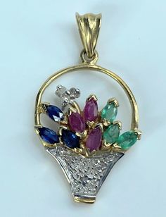 14k Yellow Gold Sapphire, Ruby, Emerald, and Diamond Flower Basket Pendant. It's in excellent condition.  Each set of colored stone totals approx. .15 carats. There are 3 tiny round diamonds totaling approx. .02 carats.  The pendant weighs 1.7 grams. It measures 1 inch top to bottom and 9/16 inches wide.  Retail $495 Multi-stone Diamond Pendant Gemstones, Basket Pendant, Ruby Emerald, Colored Stone, Diamond Flower, Flower Basket, Houston Tx, Stone Color, Round Diamonds