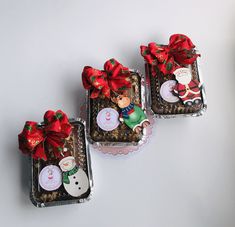 three small cakes decorated with red bows and decorations on top of each other in tin foil