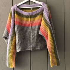 a multicolored sweater hanging on a wall