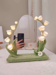 a woman taking a selfie with her cell phone in front of a flower arrangement