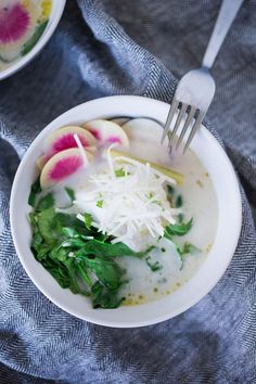 a bowl of soup with spinach, radishes and cheese