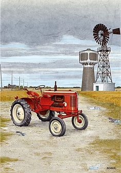 an old red farmall tractor parked in front of a windmill on a dirt road