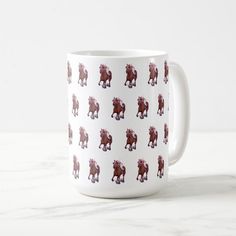 a coffee mug with horses on it sitting on a table next to a white wall