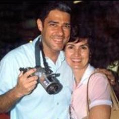 a man and woman taking a selfie with their camera in front of them at night