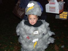 a young boy dressed up in a costume made to look like a cloud with lightning bolt on it