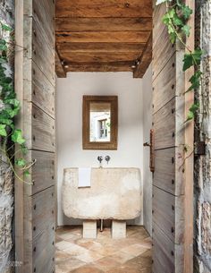 a bathroom with a sink and mirror in the wall next to wooden planked walls