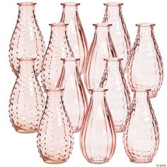 a group of pink vases sitting next to each other on a white table top