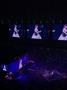 the stage is lit up with four large screens displaying images of women in evening gowns