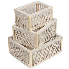 three white baskets stacked on top of each other in front of a light pink background