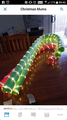 a large green and red tube with lights on it sitting on top of a wooden table