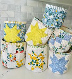 four quilted baskets sitting on top of a counter