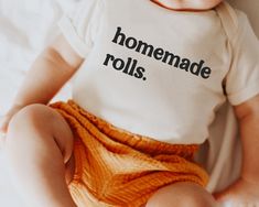 a baby wearing a t - shirt that says homemade rolls on it's chest