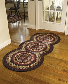 four different rugs are shown on the floor and in front of an open door