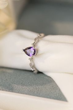 a purple ring sitting on top of a white napkin