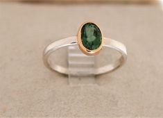 SOLD. This ring is available by special order only. Takes 1 week  if you use a stone I have in stock . I have stones in stock now oval , pear,square, square cushion cut.   Message me with your size and I will send pictures of the stones I have to choose from. .( The  sold stacking ring in the photos  has a 91ct oval green tourmaline ,which is set in an 18K gold bezel . The stone measures 7.5x5mm and weighs 1.8 grams. The sterling silver shank is 2mm in diameter. The ring weighs 1.8 grams total. Classic Oval Tourmaline Emerald Ring, Oval Tourmaline Solitaire Jewelry, Classic Oval Tourmaline Ring, Oval Solitaire Tourmaline Jewelry, Elegant Oval Tourmaline Emerald Ring, Oval Tourmaline Emerald Ring For Anniversary, Oval Tourmaline Emerald Ring With Bezel Setting, Modern Oval Tourmaline Rings, Oval Emerald Ring With Tourmaline For Anniversary