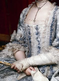 Pearl necklace, diamond cross and large diamond on leather choker, white silk mitts with revers, elbow length close sleeves with lace engageantes, lace and silk ruches to white and blue silk gown, matching stomacher, closed fan. Detail from Infanta Maria Luisa de Borbon, gran duquesa de Toscana by Anton Rafael Mengs, circa 1770. crop from portrait found at http://thepragmaticcostumer.wordpress.com/2013/05/07/an-appetite-for-fashion-decadence-a-brief-history-of-stomachers/ Rococo Costume, 1770s Fashion, French Monarchy, Prado Madrid, Rococo Fashion, Century Dress, 18th Century Fashion, Portrait Paintings, Century Clothing