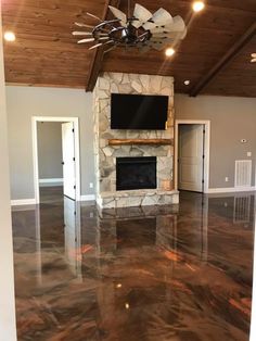 an empty living room with a fireplace and flat screen tv