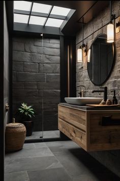 a modern bathroom with stone walls and flooring is pictured in this image, there are two sinks on the counter