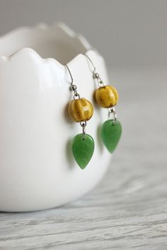 Lovely boho earrings with yellow ceramic 10 mm beads, green glass leaf beads, stainless steel jumping rings and stainless steel earring hooks. Earring hooks are from nickel free and lead free metal. Unique jewelry for you and a great gift for someone special! *The total lenght of earrings is about 53 mm including earring hooks. Other earrings of my shop you can see here: https://www.etsy.com/shop/NaTavelli?section_id=13757927 Thanks for visit. Green Leaf Earrings, Green Beaded Pierced Earrings, Nature-inspired Jewelry With Dangling Beads For Gifts, Everyday Green Round Bead Earrings, Everyday Green Round Beaded Earrings, Green Beaded Earrings, Earrings Ceramic, Plant Earrings, Crystal Pearl Earrings