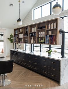 an open kitchen with lots of counter space and shelves on the wall, along with black chairs