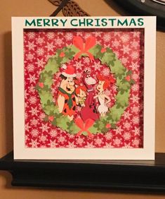 a christmas card with an image of two cartoon characters in a wreath on the front