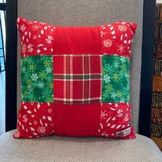 a red and green pillow sitting on top of a chair