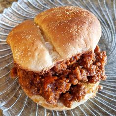 a sloppy joe sandwich sitting on top of a glass plate