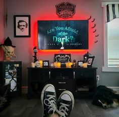 a person's feet in front of a neon sign that reads are you afraid to drink dark?