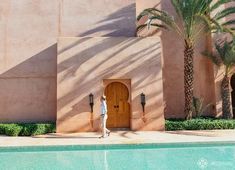 a person walking past a building with a pool