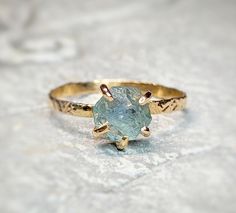 a close up of a ring with a stone in the middle on a white surface