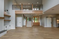 an empty living room with wood floors and stairs