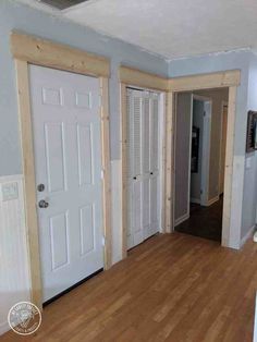 an empty living room with wood floors and white doors